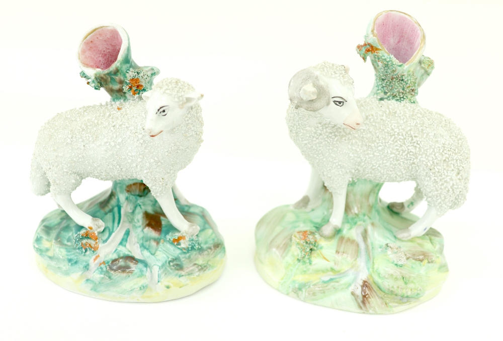 A pair of Staffordshire pottery spill vases, modelled as a frit decorated ram and a ewe, each 13.