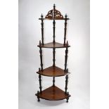 A Victorian walnut and ebonised four tier corner whatnot, with spiral turnings,