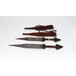 Two West African daggers, with steel blades, leather and snakeskin covered handles and scabbards,