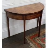A George III mahogany tea table, the hinged demi lune fold-over top, on square tapered legs,