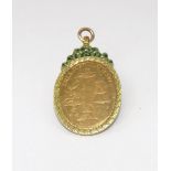 A 19th century gold and enamel oval pendant with a laurel chased border and green and black