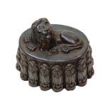 A Victorian tinplate recumbent Lion jelly mould, no. 114, with fluted sides, 14cm high, 20.5cm long.