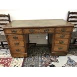 An Edwardian oak kneehole desk, the inse