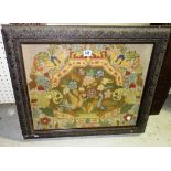 An early 20th century needlework tapestry depicting birds of paradise, framed and glazed.