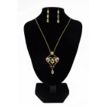 An Art Nouveau rose gold, peridot & half-pearl open double scroll pendent necklace,