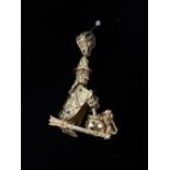 A modern 9ct gold and gem set pendant in the form of an articulated witch stirring her cauldron