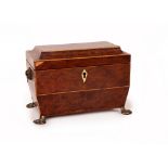 A Regency burr yew tea caddy, circa 1810, of sarcophagus form and with boxwood stringing,