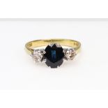 A modern 18ct gold, sapphire and diamond three stone ring,