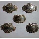 A group of three silver decanter labels, embossed with foliate decoration, detailed Gin,