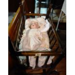 A German bisque head porcelain doll and an oak rocking crib, (2).