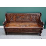 A mid 20th century carved oak lift top box seat settle with lion masks arm supports,