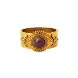 A Victorian gold and carbuncle garnet set oval hinged bangle, circa 1870,