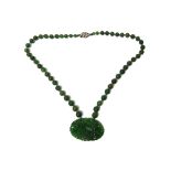 A carved jade and green stone bead necklace,