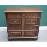 A Charles II oak chest of four long graduated geometric drawers, on bracket feet,