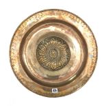 A German brass alms dish, 16th century, raised boss decorated with a mask within a foliate border,