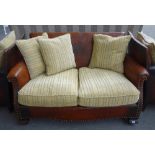 A mid 20th century studded brown leather upholstered two seat sofa with embossed Tudor rose back,