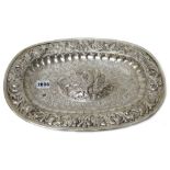 A Portuguese silver dish, of oval form, the centre decorated with a large bird, with floral sprays,