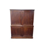 A George III mahogany double height cupboard, the lower doors enclosing a pair of drawers,