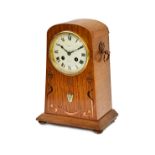 An oak Arts and Crafts mantel clock, with copper and mother-of-pearl inlay,