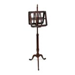 A George IV mahogany duet music stand on reeded height adjustable column and tripod base.