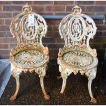 Probably Coalbrookdale; a pair of white painted cast iron garden seats, on splayed supports,