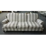 A 20th century two tone dog tooth striped three seat sofa on tapering square supports and silvered