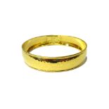 An 18ct gold circular bangle with martele decoration, detailed 'IPPOLITA Fatto A Mano 18K',