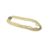 A three row necklace of uniform cultured pearls, on a 9ct gold,
