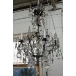 A patinated metal and glass eight light chandelier, 20th century,
