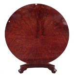 A William IV mahogany circular snap top breakfront table with radial veneered top on carved and