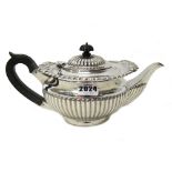 A silver teapot, of compressed circular form, with partly fluted decoration,