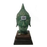 A green glazed head of Buddha, modelled with eyes close and serene expression,