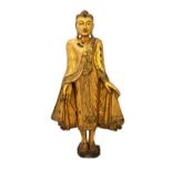 A giltwood figure of standing Buddha, with inlaid sequinned robes, 74cm high.