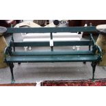 A 19th century green painted garden bench, with wooden slats on moulded cast iron supports,