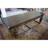 A 17th century style oak refectory table, on carved bulbous supports united by perimeter stretcher,