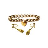 A gold bracelet, in a scrolled curb link design, detailed 9 C, on a gold heart shaped padlock clasp,