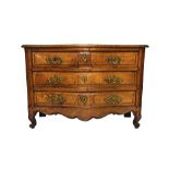 An 18th century French walnut serpentine three drawer commode, on scroll feet,