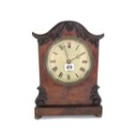 A Victorian mahogany mantel timepiece, the arched case carved with foliage,