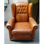 A pair of mid 20th century French brass studded leather upholstered wingback armchairs on tapering