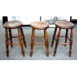 A set of four late 19th century elm bar stools with turned supports, each approximately 54cm high.