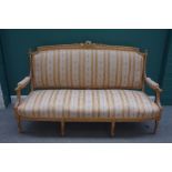 A Louis XV style gilt framed sofa with carved crest and bow seat on fluted supports, 108cm high.