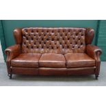 A mid-20th century studded brown leather upholstered three seat sofa,