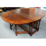 A large 18th century style oak oval double gateleg action dining table on baluster turned supports,