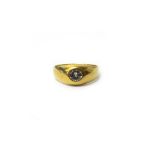 A gold and diamond set single stone signet style ring, gypsy set with a circular cut diamond,