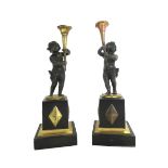 A pair of Regency gilt and patinated bronze figural candlesticks (lacking sconces),
