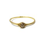 A 9ct gold and diamond set seven stone cluster bangle, claw set with circular cut diamonds,