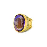 A gold and platinum ring, collet set with a large oval cut amethyst,