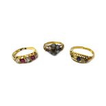 A gold, diamond and ruby set five stone ring, mounted with three cushion shaped diamonds,