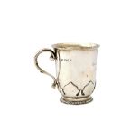 A silver christening mug, with a scrolling handle, raised on a gadrooned circular foot,