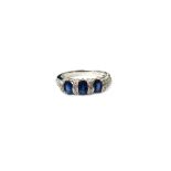 A white gold, sapphire and diamond ring, mounted with three oval cut sapphires,